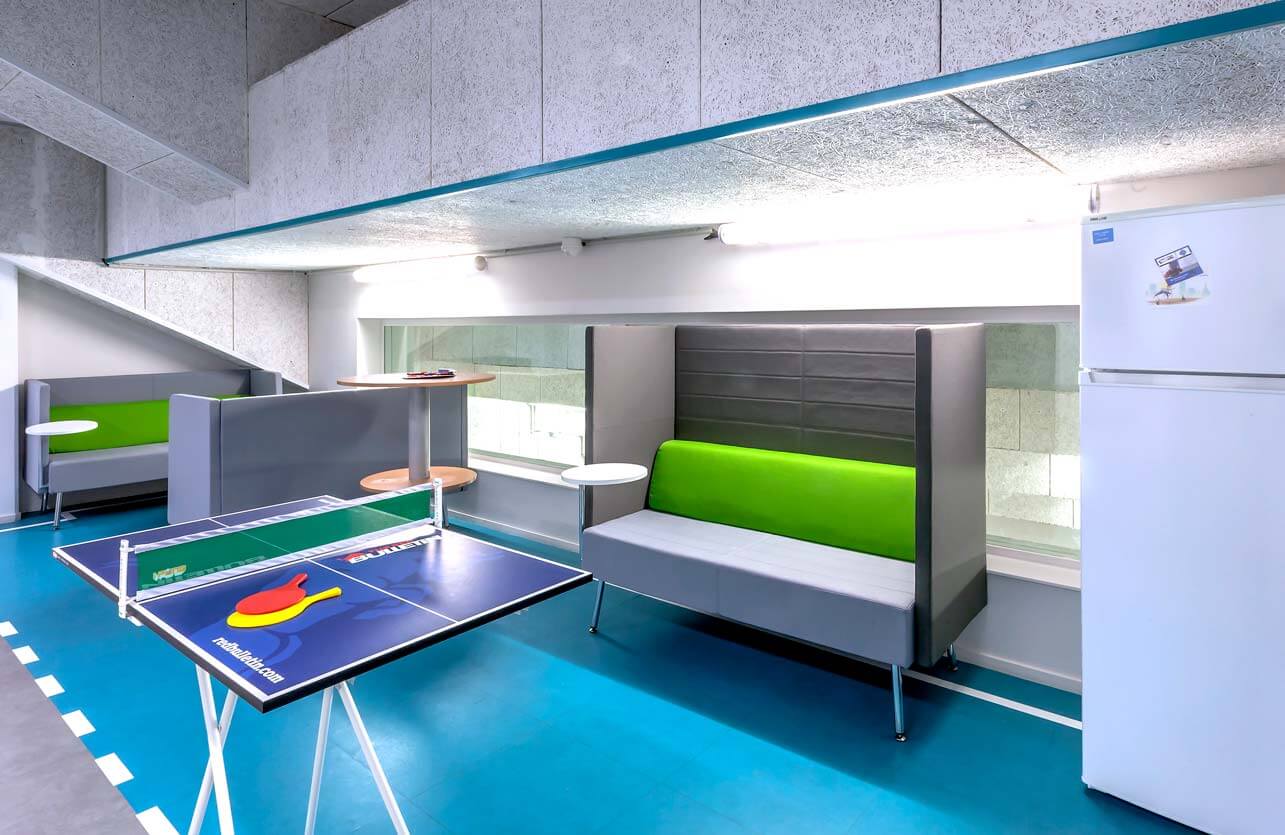 Photo de présentation de l'aménagement d'une salle de détente mêlant l'environnement sportif à l'esprit startup dans les locaux Jean Bouin "Le Tremplin" à Paris