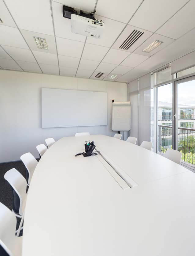 Photo de présentation de l'aménagement d'une salle de réunion équipée d'une grande table ovale pour les bureaux de Léon Grosse à Montigny-le-Bretonneux (Yvelines)